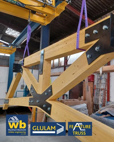 Glulam Feature Trusses joined with bolted black steel plates; Wyckham Blackwell company logo bottom left.